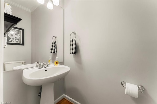 half bathroom featuring baseboards and ornamental molding