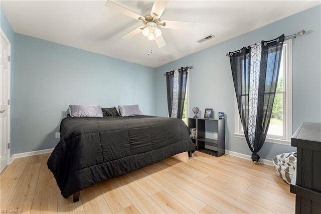 bedroom featuring visible vents, light wood-style floors, baseboards, and multiple windows