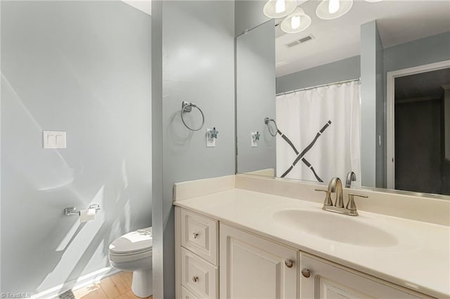 bathroom with vanity, toilet, wood finished floors, and visible vents