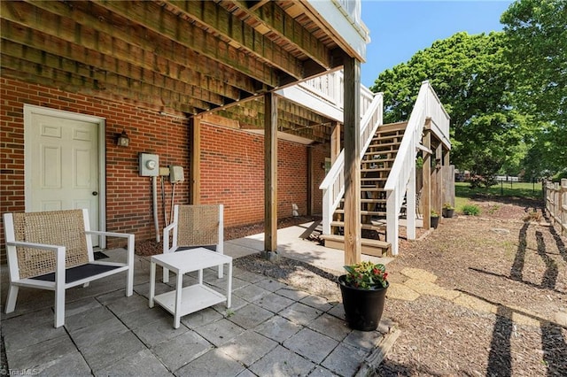 view of patio with stairway and fence