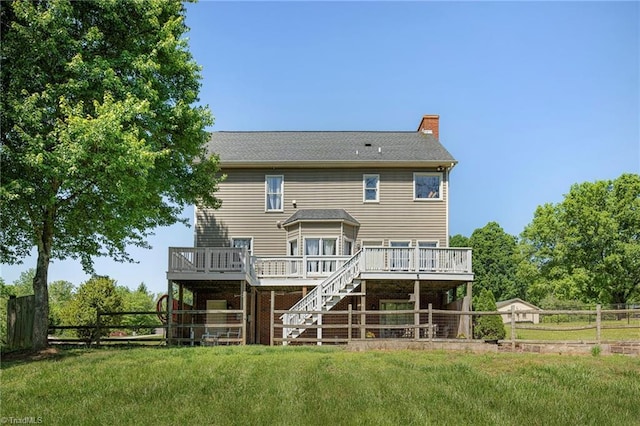 back of house with a chimney, a wooden deck, fence, a yard, and stairs