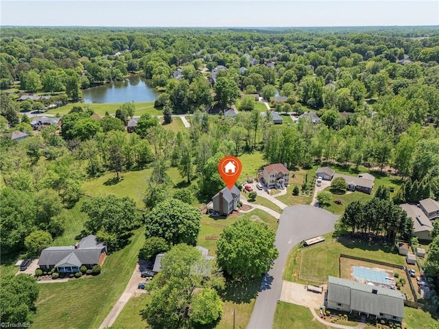 birds eye view of property with a view of trees and a water view
