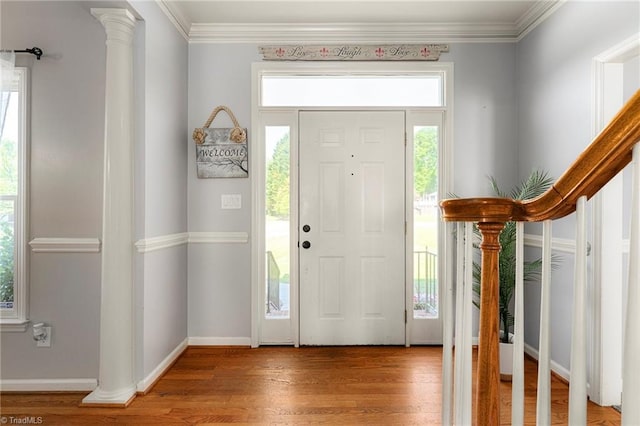 entryway with crown molding, baseboards, and wood finished floors