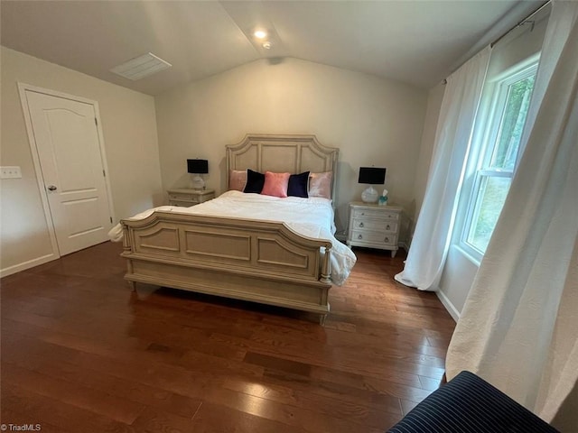 bedroom with vaulted ceiling and dark hardwood / wood-style floors