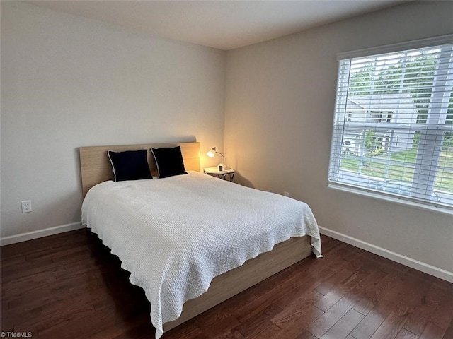 bedroom with dark wood-type flooring and multiple windows