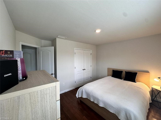 bedroom with dark hardwood / wood-style flooring and a closet