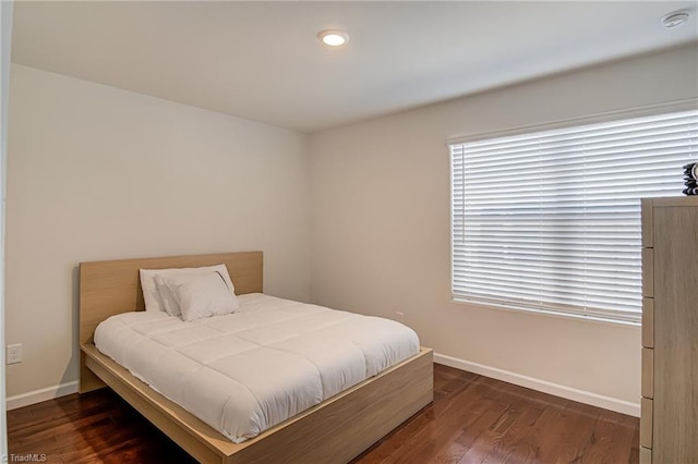 bedroom with dark hardwood / wood-style floors