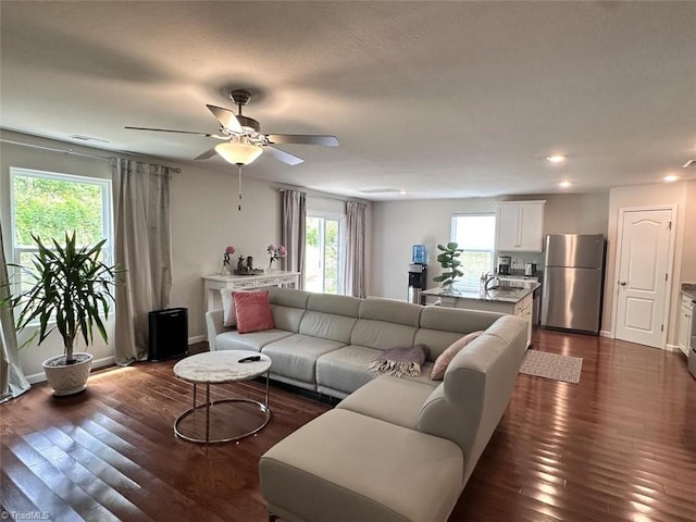 living room with dark hardwood / wood-style floors, sink, and ceiling fan