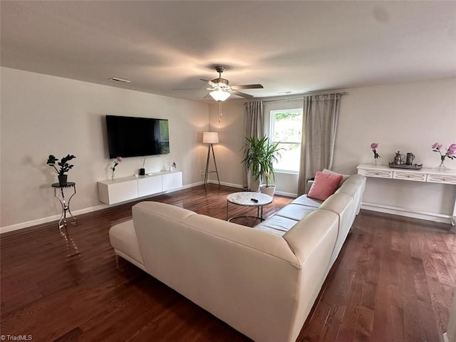 living room featuring ceiling fan and dark hardwood / wood-style flooring