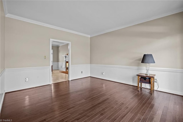 empty room with dark hardwood / wood-style floors and crown molding