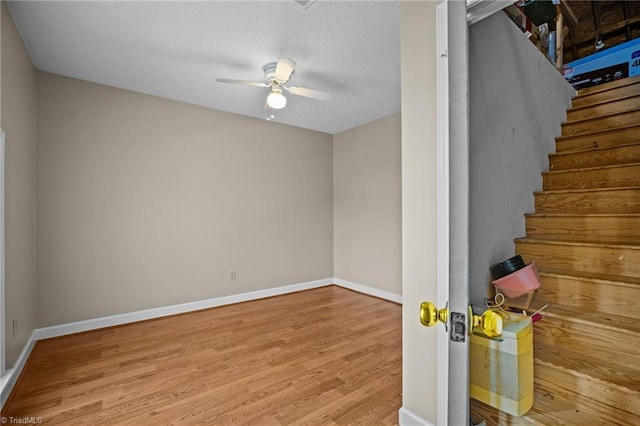 interior space featuring ceiling fan, light hardwood / wood-style floors, and a textured ceiling