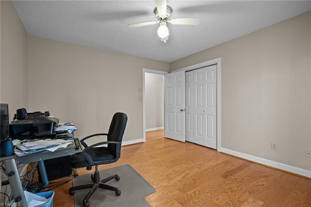 home office with ceiling fan, a textured ceiling, and light wood-type flooring