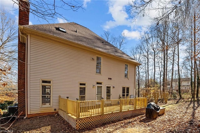 back of house featuring central air condition unit and a wooden deck