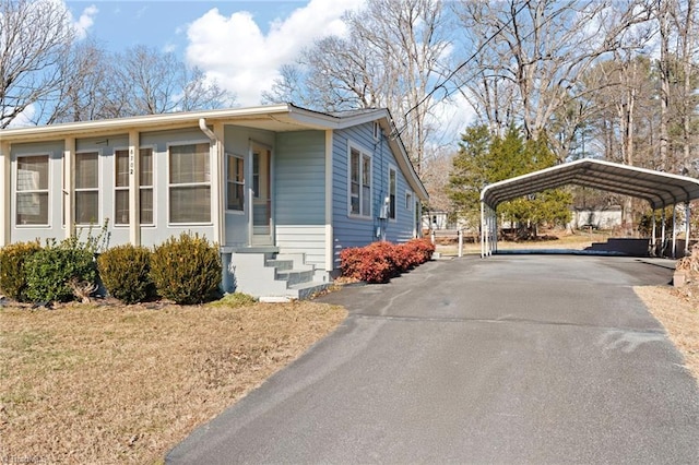 view of side of home with a yard and a carport