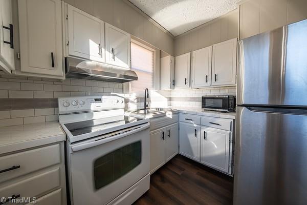 kitchen featuring white cabinets, decorative backsplash, sink, and stainless steel appliances