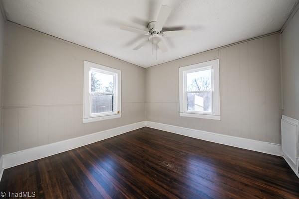 spare room featuring ceiling fan and dark hardwood / wood-style flooring