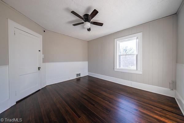 spare room featuring ceiling fan and dark hardwood / wood-style floors