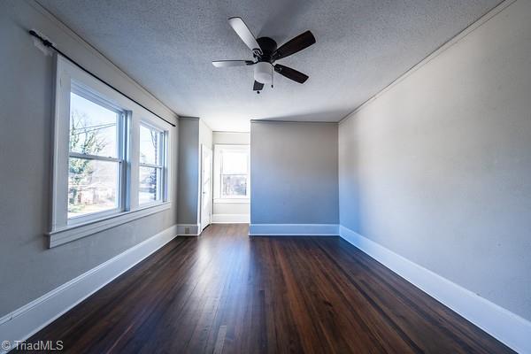 spare room featuring ceiling fan, a textured ceiling, and dark hardwood / wood-style flooring