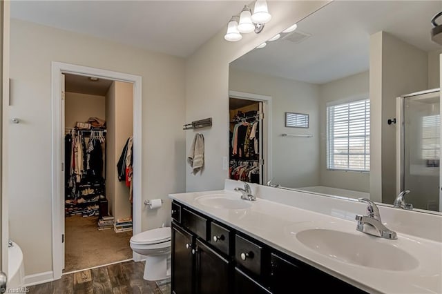 full bathroom with toilet, plus walk in shower, vanity, and wood-type flooring