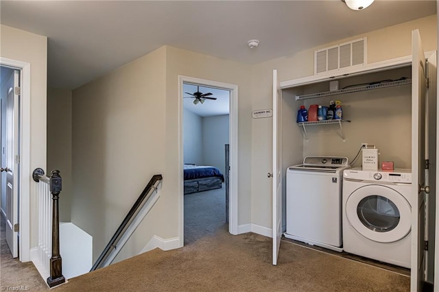 laundry room with washing machine and clothes dryer and light carpet