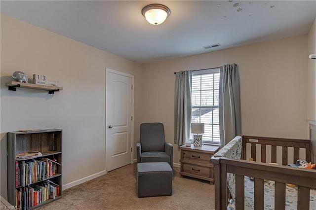 bedroom featuring a nursery area and light carpet