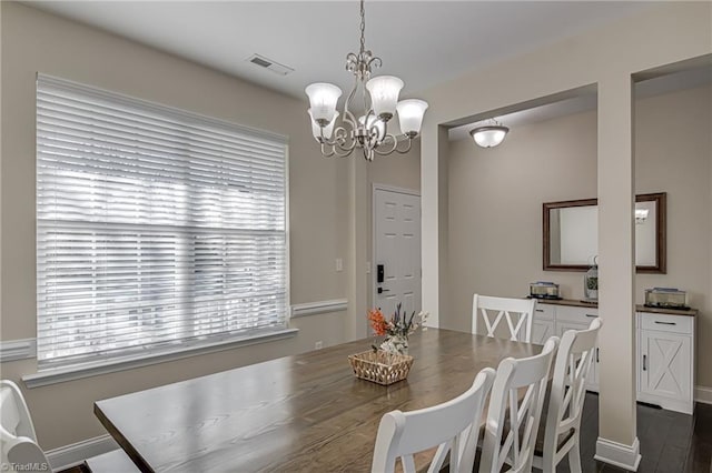 dining area with a chandelier, plenty of natural light, and dark wood-type flooring