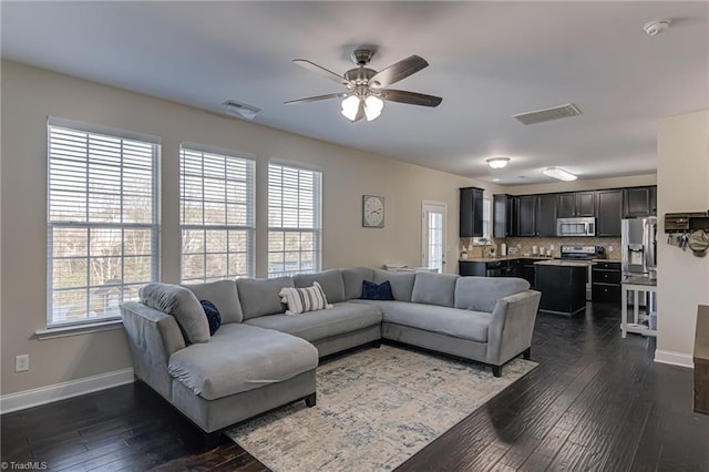 living room featuring ceiling fan and dark hardwood / wood-style floors