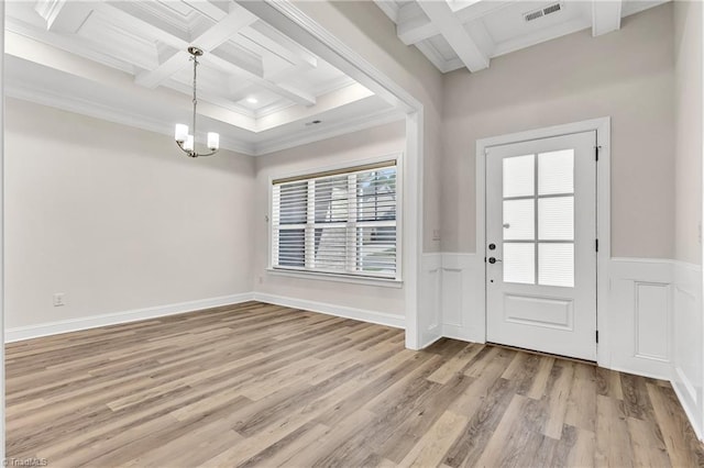 foyer featuring beam ceiling, coffered ceiling, light wood-type flooring, ornamental molding, and a chandelier