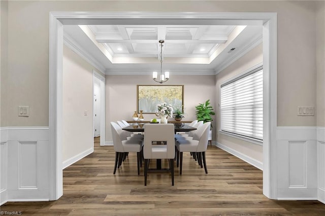 dining area with beamed ceiling, ornamental molding, coffered ceiling, and hardwood / wood-style floors