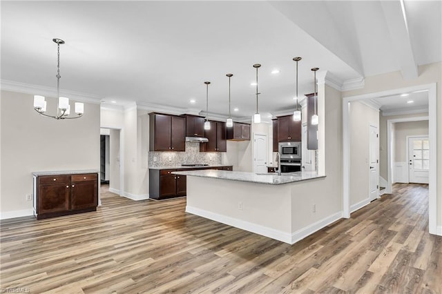 kitchen with decorative light fixtures, light stone countertops, decorative backsplash, and appliances with stainless steel finishes