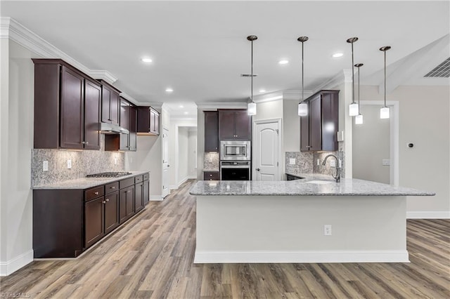 kitchen featuring light stone countertops, appliances with stainless steel finishes, sink, hanging light fixtures, and kitchen peninsula