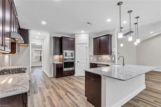 kitchen featuring decorative light fixtures, decorative backsplash, appliances with stainless steel finishes, and kitchen peninsula