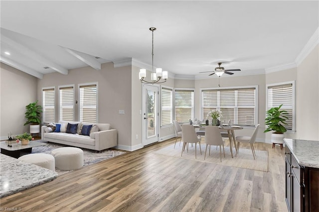 living room featuring beam ceiling, plenty of natural light, ceiling fan with notable chandelier, and light hardwood / wood-style flooring