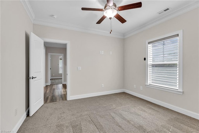 carpeted empty room featuring ceiling fan and crown molding