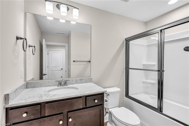 full bathroom featuring toilet, enclosed tub / shower combo, and vanity