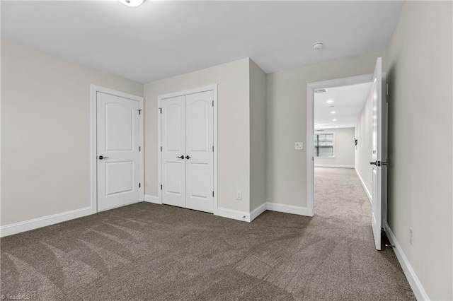 unfurnished bedroom with a closet and dark colored carpet