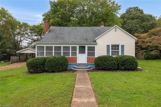 view of front of property with a sunroom and a front yard