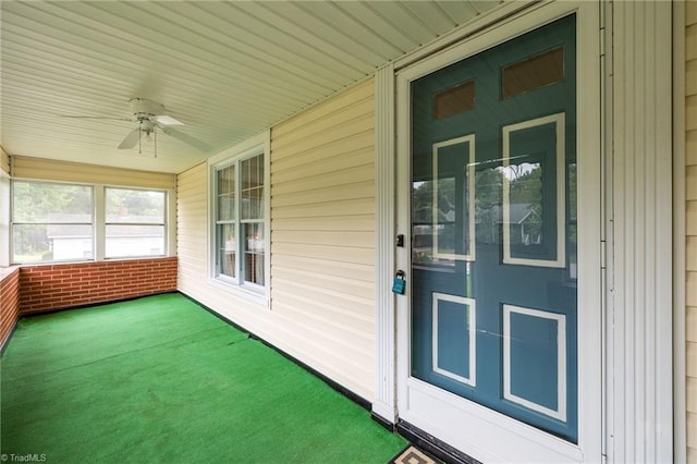 unfurnished sunroom with ceiling fan