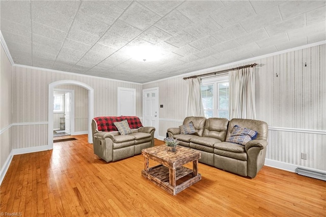 living room featuring a wealth of natural light, hardwood / wood-style flooring, and crown molding