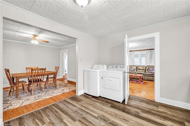 clothes washing area with washing machine and dryer, ornamental molding, hardwood / wood-style floors, and ceiling fan