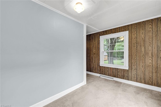 spare room with wooden walls, crown molding, and carpet flooring