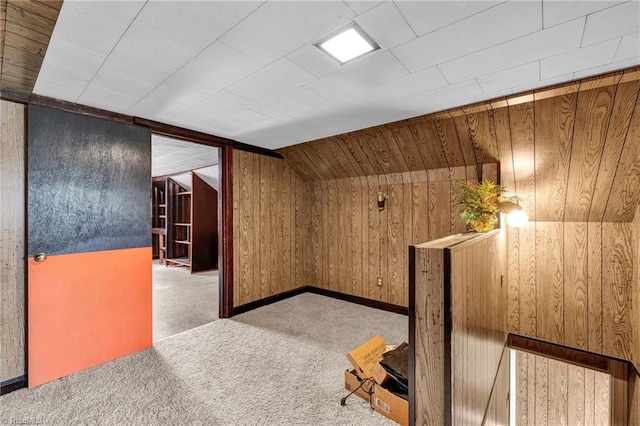 bonus room featuring carpet, lofted ceiling, and wood walls