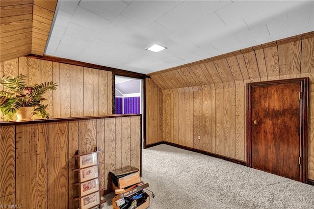 bonus room with carpet floors, lofted ceiling, and wooden walls