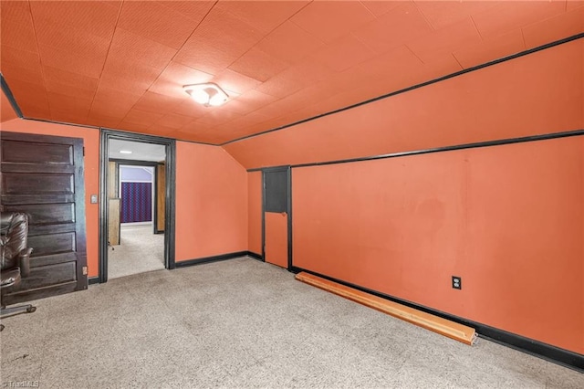 bonus room featuring vaulted ceiling and light colored carpet