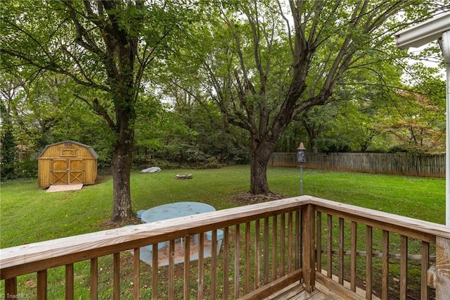 wooden terrace with a storage unit and a yard