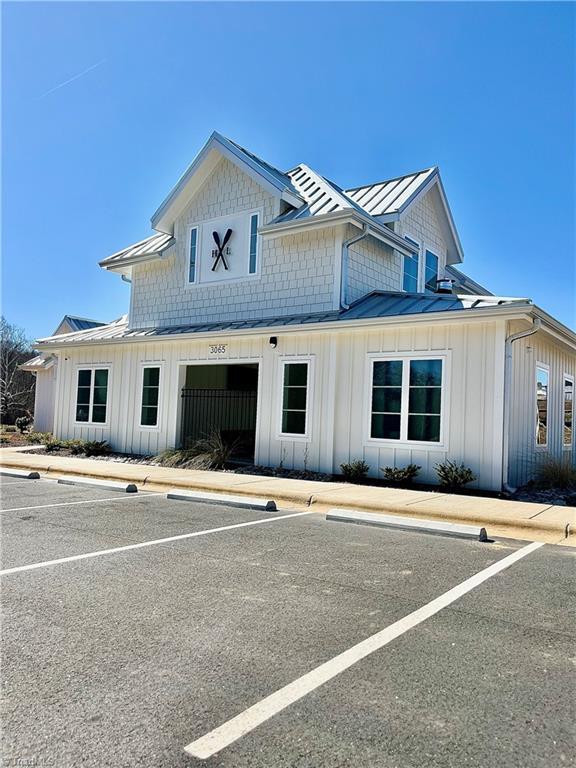 516 Raspberry Hill Rd, Winston-Salem, NC 27106 - view of front of home with board and batten siding, a standing seam roof, uncovered parking, and metal roof