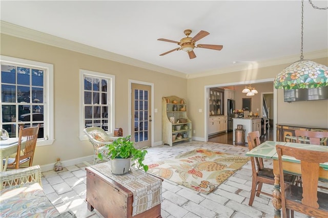 interior space with baseboards, crown molding, and a ceiling fan