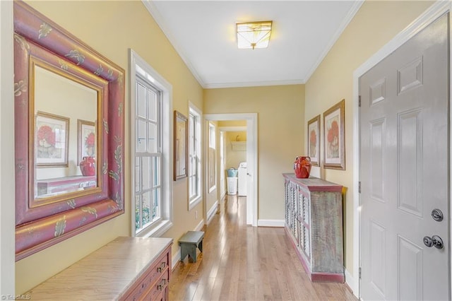 corridor with washer and dryer, baseboards, light wood-style floors, and crown molding