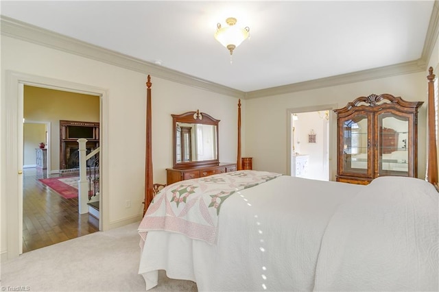 bedroom featuring ensuite bath, carpet, baseboards, and ornamental molding