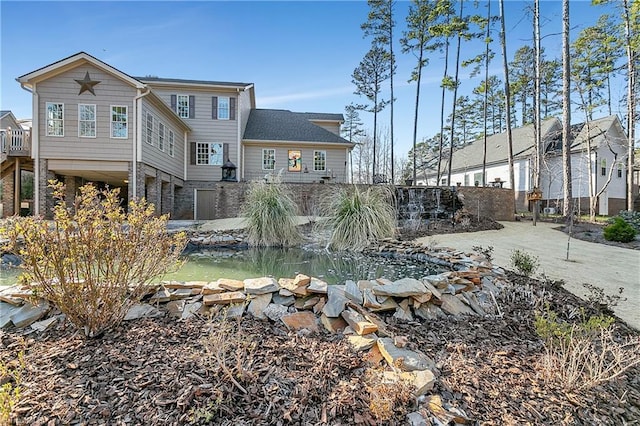 back of property with a garden pond